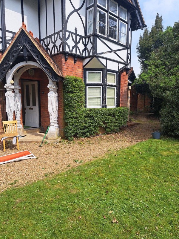 Front hedge overgrown around the entrance before cutting for a private home near Skirmett